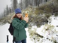 Active woman takes snow photographs on cell phone