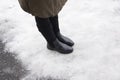 Legs of a girl in winter boots walking on a snowy road. Royalty Free Stock Photo