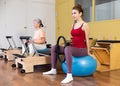 Active women perform exercises with fitness balls and Pilates rings