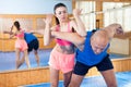 Active woman with professional trainer are training captures on the self-defense course in gym