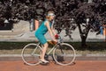 Active women in vintage clothing cycling in city park during the festival Retro Cruise