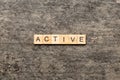 active word written on wood block. active text on table, concept