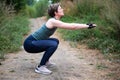 Active 36 year old white woman doing a squat outdoors, Belgium