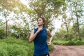 Active young Asian woman healthy lifestyle running at tropical forest trail Royalty Free Stock Photo
