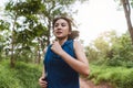 Active young Asian woman running at tropical forest trail Royalty Free Stock Photo