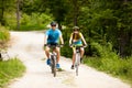 ACTIVE Young couple biking on a forest road in mountain on a spring day Royalty Free Stock Photo