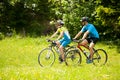 ACTIVE Young couple biking on a forest road in mountain on a spring day Royalty Free Stock Photo