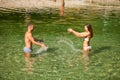 Active young couple plays in shallow water on a hot summer morning