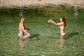 Active young couple plays in shallow water on a hot summer morning