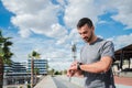 Active Young Energetic Sports Man Checking His Progress on Smart Watch Gear During Outdoor Running Workout. Athletic Royalty Free Stock Photo