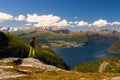 Backpacking young girl on lookout of Norwegian fjords and mountains, Norway