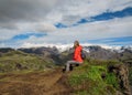 Active young hiker woman small backpack sitting enjoying volcano landscape with glacier mountains green valley and snow Thorsmork Royalty Free Stock Photo