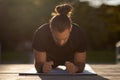 Active young man in fitwear holds plank position in park Royalty Free Stock Photo