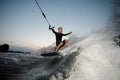 Active and young man riding on a wake board at the evening Royalty Free Stock Photo