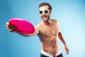 Active young man in summer clothes throwing frisbee disc