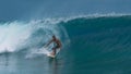 Active young man surfs a big turquoise barrel wave on a perfect day in summer. Royalty Free Stock Photo