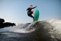 Active and young wake surfer jumping on a wake board down the river Royalty Free Stock Photo