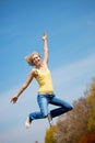 Active young woman jumping high in sunshine
