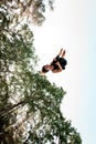 Active young woman jumping high and tumbling in the air against the blue sky. Royalty Free Stock Photo