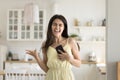 Overjoyed woman sing song holds cellphone dancing at home Royalty Free Stock Photo