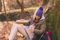 Woman taking a break pouring hot tea while mountaineering on an autumn day Royalty Free Stock Photo