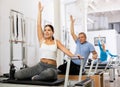Active young woman stretching upper body practicing Pilates exercise in studio with elderly people Royalty Free Stock Photo