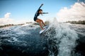 Active young woman in swimsuit vigorously ride the wave on surfboard