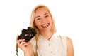 Active young woman taking photos with retro camera isolated over Royalty Free Stock Photo