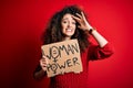 Activist with curly hair and piercing protesting holding poster with woman power message stressed with hand on head, shocked with