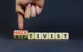 Activist or hacktivist symbol. Businessman turns wooden cubes and changes the word Activist to Hacktivist. Beautiful grey table Royalty Free Stock Photo