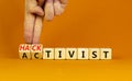 Activist or hacktivist symbol. Businessman turns wooden cubes and changes the word Activist to Hacktivist. Beautiful orange table