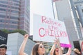 An activist holds a sign that says,