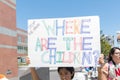 An activist holds a sign that says,