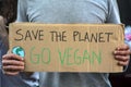 Activist with `Save the planet, Go Vegan` placard