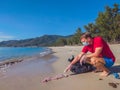 Activist volunteer Man in medical face mask pick up garbage that pollute beach sand near sea. Problem of spilled rubbish