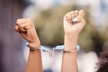 Activist woman hands fist, handcuffs and social justice protest of women protesting outdoor. Hand view of empowerment