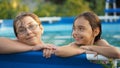 Activities on the pool. Cute kids - sister and brother swimming and playing in water in swimming pool in aquapark Royalty Free Stock Photo