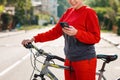 Activity. A close up portrait of young beautiful woman uses her phone while riding a Bicycle. Outdoor. Concept of modern Royalty Free Stock Photo