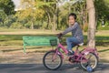 Activity morning in public park Thailand, Asian child girl practicing biking bicycle with two supporter wheels, first time with