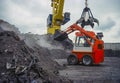 Wheel-type loader under a grab head.