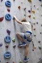 Activity of rock-climbing on artificial climbing wall, Caucasian boy with safety line Royalty Free Stock Photo