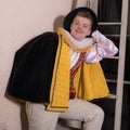 Actor dressed historical costume in interior of old theater.