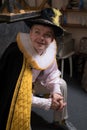 Actor dressed historical costume in interior of old theater.