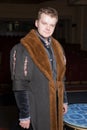 Actor dressed historical costume in interior of old theater.