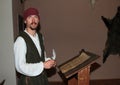 Actor in historical costume behind writing table