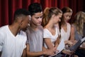 Actors reading their scripts on stage