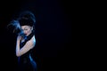 Actress brunette woman with high hair, a mask with feathers and corset in old style Royalty Free Stock Photo