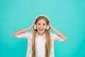 She is actually a big music fan. Happy little child enjoy music playing in headphones. Little girl child listening to
