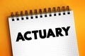 Actuary - business professional who deals with the measurement and management of risk and uncertainty, text concept on notepad