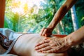 Acupressure massage in spa centre outdoor. Woman at acupressure back massage, masseur`s hands close up. Body therapy for healthy Royalty Free Stock Photo